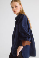 Camisa oversize azul con cuero marrón
